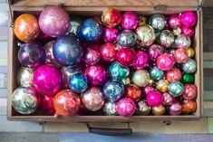 a box filled with lots of different colored ornaments