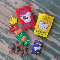 three felt bookmarks with dog, cat and food on them sitting on a wooden surface