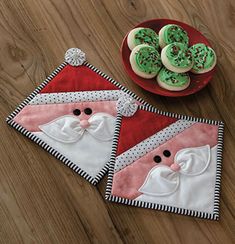 two christmas themed placemats with green frosting and decorated cookies in the shape of santa's hats