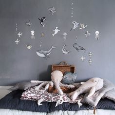 a bed with two stuffed animals on it and under the sea creatures wall decals