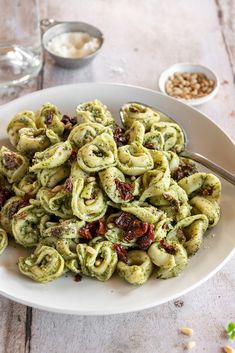 a white bowl filled with pasta and pesto