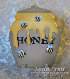 a honey jar with bees on it and the word honey written in black letters is shown