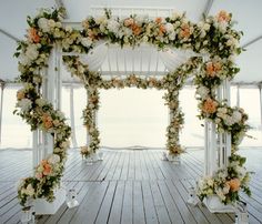 an outdoor wedding setup with white and orange flowers