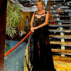 a woman in a black dress standing on some stairs