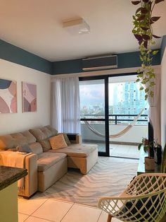 a living room filled with furniture next to a sliding glass door and a window covered in curtains