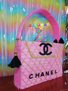 a pink chanel handbag made out of paper mache and tassels