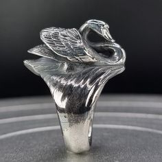 Large Swan ring. The ring is an original design by Richard Chown, hand carved in wax and then lost wax cast using recycled sterling silver right here in the heart of London. Made using 100% recycled 925 sterling silver and hallmarked.  This is a large ring, and it is solid all the way through (not hollow). Weighing approx 26 grams, it's a whopper, and may not be suited to part time ring wearers. Finish options are: -Silver -Oxidised (blackened as in the main listing photo) -Silver Engraved (with Swan Ring, Swan Jewelry, Bird Ring, Bird Rings, Silver Swan, Animal Ring, Chunky Ring, Cursive Font, Concert Outfits