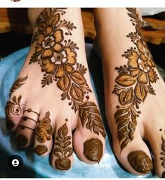 two feet with henna tattoos on them, one is brown and the other is white