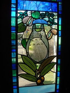 a stained glass window with a totoro holding an umbrella