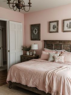 a bedroom with pink walls and wooden furniture