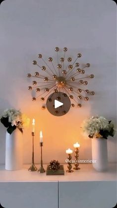 a white shelf topped with vases filled with flowers next to candles and other decorations