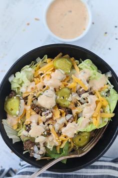 a black bowl filled with salad and dressing