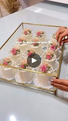 someone is decorating a wedding cake with pink flowers and lace on the bottom layer