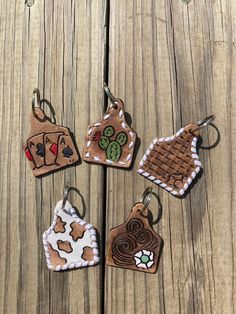 four different shaped cookies are hanging on a wooden surface, one is decorated with icing and the other has chocolate frosting