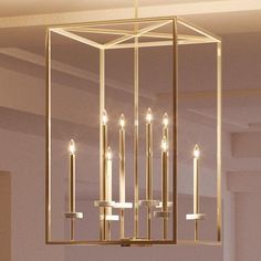 a gold chandelier with candles hanging from it's sides in a room