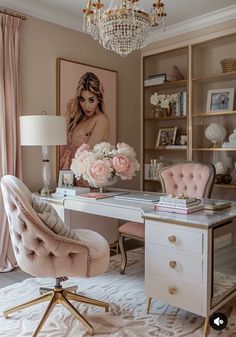 an elegant home office with pink and gold accents, chandelier, chair, desk and painting on the wall