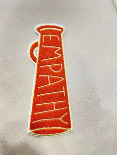 an embroidered sticker on the back of a white jacket