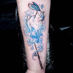 a rabbit with an umbrella tattoo on the leg is shown in blue ink and has waves coming out of it