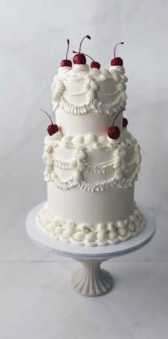 a three tiered cake with cherries on top