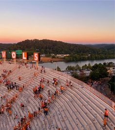 an aerial view of people in orange vests standing on the side of a stadium