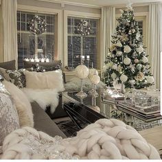 a living room filled with furniture and a christmas tree in the window sill next to a couch