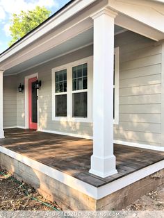 a house with white siding and red door