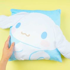 someone is holding up a pillow with an animal on it