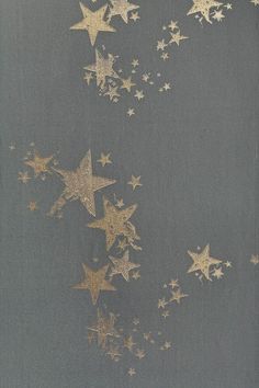 gold stars are flying in the air against a gray background