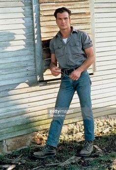 a man standing in front of a house with his hands on his hips and looking at the camera