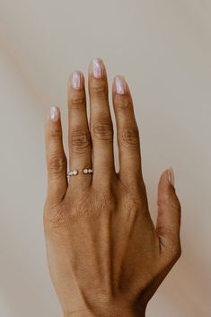 a woman's hand with two rings on it