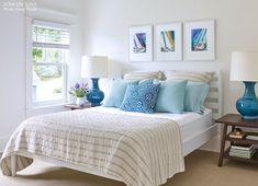 a white bed sitting next to two blue vases