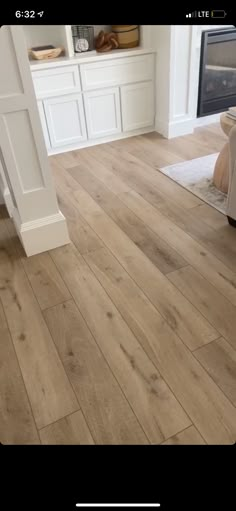 a living room with white furniture and wood floors