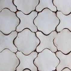 a close up view of a white tile wall with hexagonal tiles on it