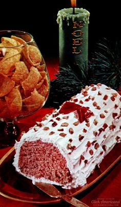 a piece of cake sitting on top of a plate next to a glass bowl filled with chips