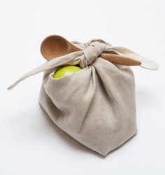 an apple in a linen bag with a wooden spoon sticking out of the top one