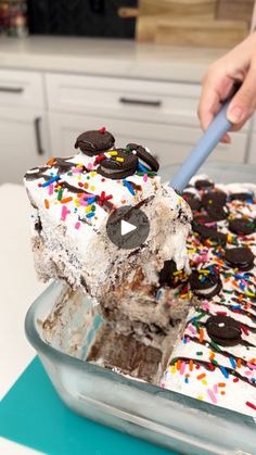 someone is cutting into a cake with ice cream and sprinkles on it