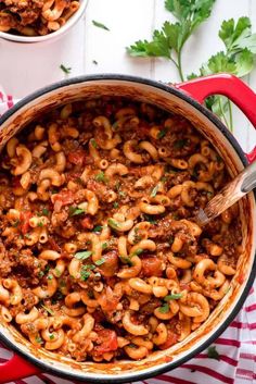 two bowls filled with chili macaroni and cheese on top of a striped cloth