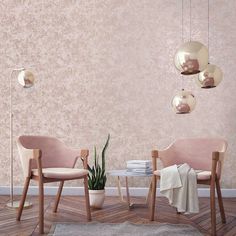 two chairs and a table in front of a pink wall with hanging lights on it