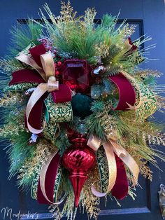 a christmas wreath on the front door with red and green ornaments hanging from it's sides