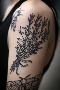 a black and white photo of a woman's arm with an insect on it