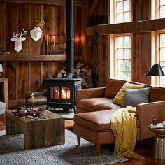 a living room filled with furniture and a wood burning stove in the middle of it