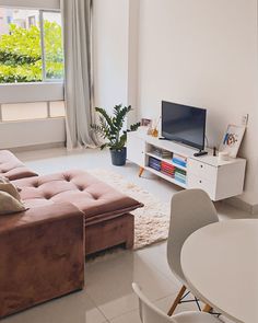 a living room filled with furniture and a flat screen tv sitting on top of a white table