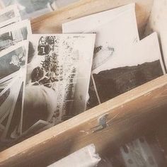 an open wooden box filled with pictures and papers