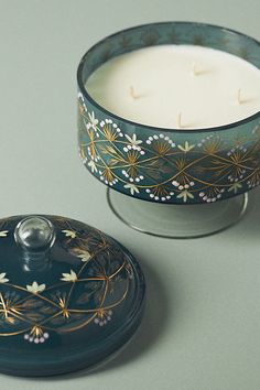 a candle sitting on top of a table next to a container