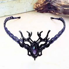 "A blackened woodland stag branch design with a deep purple centerpiece is the focal point of this unisex Celtic elven circlet, inspired by the dark forests of Ireland and Scotland. The Celtic weave base is black with purple accent wires woven in. The circlet can be worn by either men or women and depending on the activity level, can be worn as is, or held in place by ribbon or leather ties. We love custom work, so if you see any circlet and want to change stones, or change stone or wire colour Dark Purple Jewelry, Gold Headpiece Wedding, Black Tiara, Purple Centerpieces, Celtic Weave, Elven Jewelry, Black Crown, Headpiece Jewelry, Purple Accents