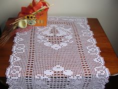 a table topped with a white doily next to a vase filled with flowers