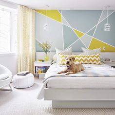 a dog laying on top of a white bed in a room with yellow and blue walls