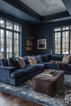 a living room filled with blue couches and pillows on top of a wooden floor