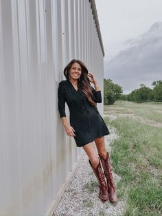 Our Black Hills Dress pairs stretchy faux suede material with playful fringe & the result is as ready for those post-rodeo celebrations as you are. Features a wrap belt with tie. 92% Polyester 8% Spandex Pressley is 5’4”, a size 25 & extra small top wearing a 2 Black Cocktail Dress Western, Black Dress With Cowgirl Boots, Western Cocktail Attire, Blazer And Cowboy Boots, Dresses To Wear With Cowboy Boots, Dress With Cowgirl Boots, Vogue Home, Dresses With Cowboy Boots, Rodeo Drive