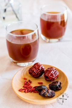 two glasses of tea and some dried fruit on a plate